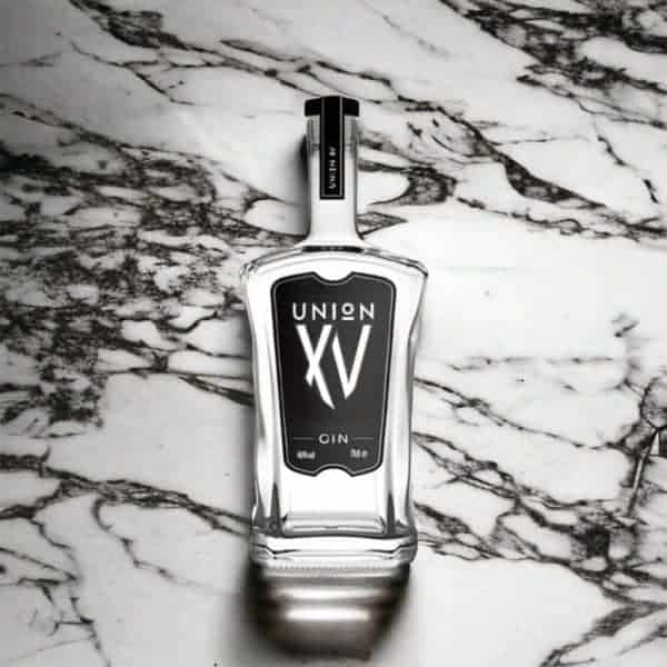 A bottle of Import placeholder for 20429 gin sitting on a marble surface.